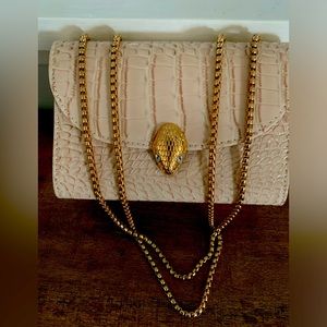 Cream colored vegan leather handbag.